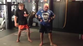 Joe Rogan kicks really hard while Duane  Ludwig holds pads