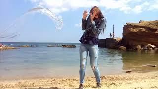 funny girl in wet jeans and a wet denim jacket on the beach