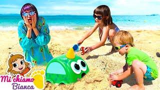 Giochi con la sabbia al mare. Dove sono le macchinine? La bambina Bianca e il suo fratellino