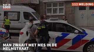 MAN ZWAAIT MET MES IN DE HELMSTRAAT