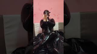 Breathplay in latex catsuit, israeli gas mask with filter, and latex surgical gloves