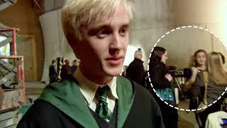 Emma Watson in the background of Tom Felton's interview