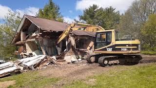 Cat 312 excavator knocking down house