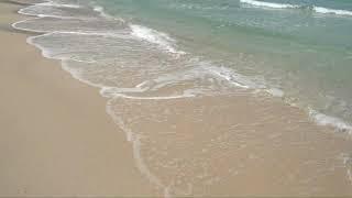 calm gentle ocean waves lap onto sand