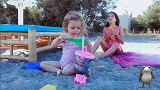 Anisia and Amelia playing on the beach with sand and other kids toys