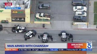 Man armed with chainsaw in standoff with police