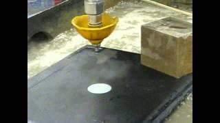 Cutting a laptop with a waterjet cutter.