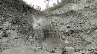 The fall of dry sand from the top of the cliff creates a cloud of smoke