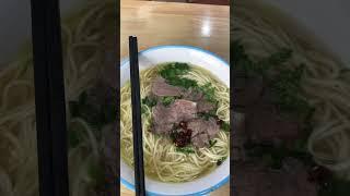 Having hot and spicy halal tasty beef noodles at a restaurant on the street of Shanghai, China