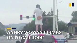 Chinese woman climbs onto car roof after argument with husband