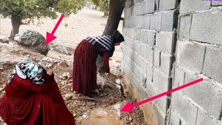 A pregnant nomadic woman resists rain to prevent it from entering her home