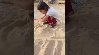 Maryam He plays in the sand