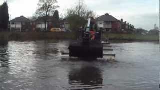 Truxor excavating and dredging silt with clamshell bucket