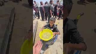 Disabled Palestinian child struggles through crowd for a meal