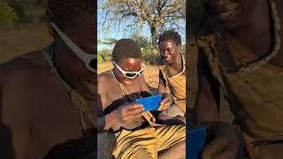 Hadzabe Tribe bushmen brothers see themselves in the mirror for the first time with sunglasses on