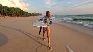 Chill out music. A beautiful surfer girl walks along the ocean shore.