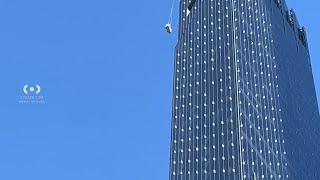 Window washing rigging swings in wind outside NYC high-rise