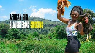 African village girl preparing two chicken for food