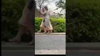 Two drunk ladies are walking on the street and then falling down. 