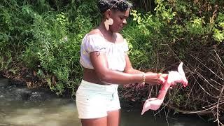 African village  girl slaughtering rabbit barefoot near the river