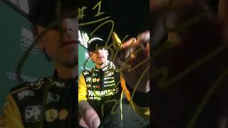Ryan Blaney signs the camera lens in victory lane 